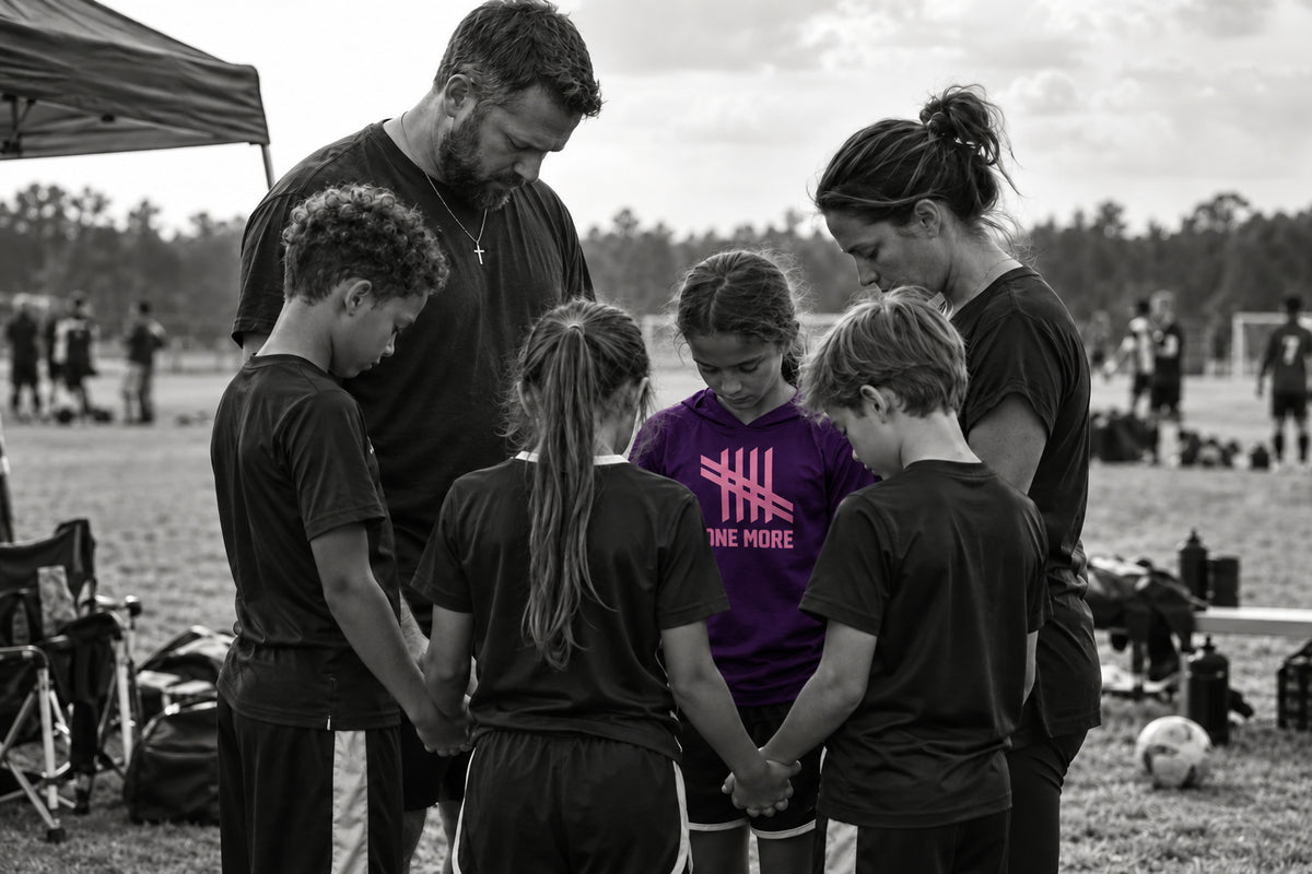Families and young athletes joining hands in a pregame prayer